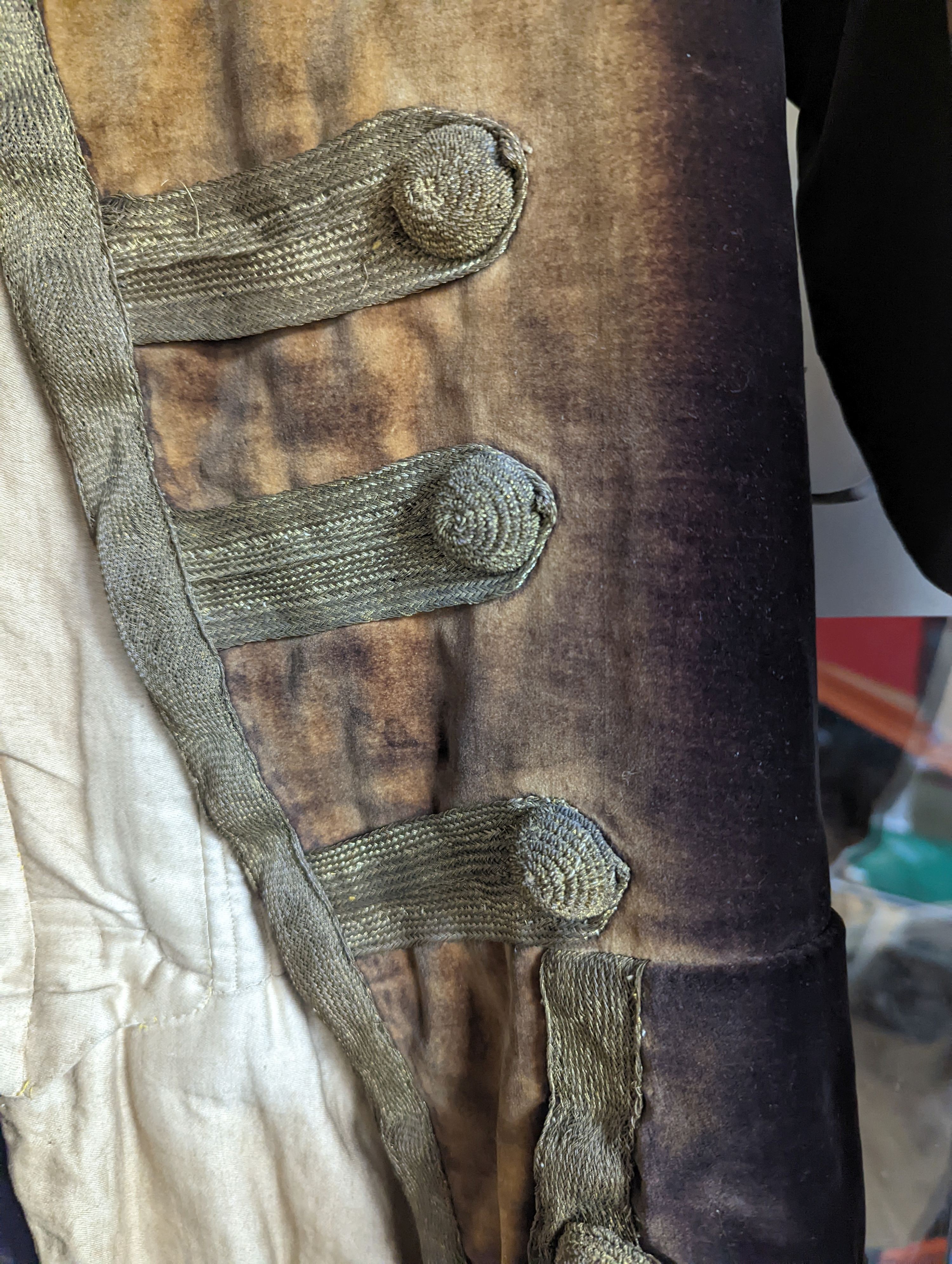A Georgian gents cream damask waistcoat, a similar waistcoat with beading applied later and a velvet and gold braided tailcoat
